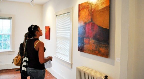 A gallery visitor admires a painting.
