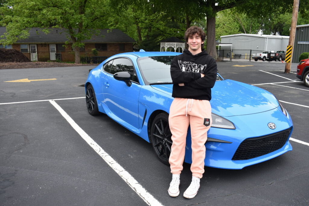 Chase Brosel standing with his vehicle at Cars on Campus.